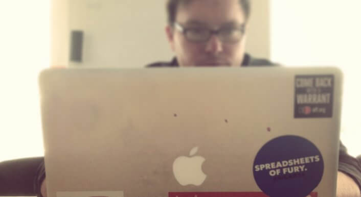Reporter vor Laptop mit Stickern