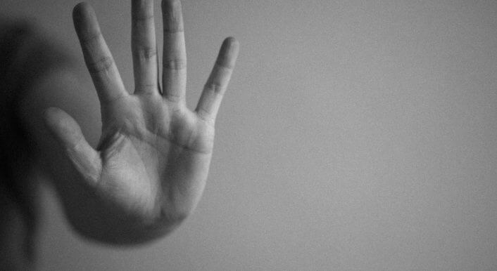 Eine Hand sagt Stopp: Ausgestreckte Handfläche.