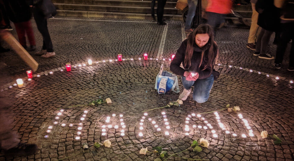Eine Frau zündet in München zum Gedenken an die Opfer des Anschlags in Hanau Kerzen an.
