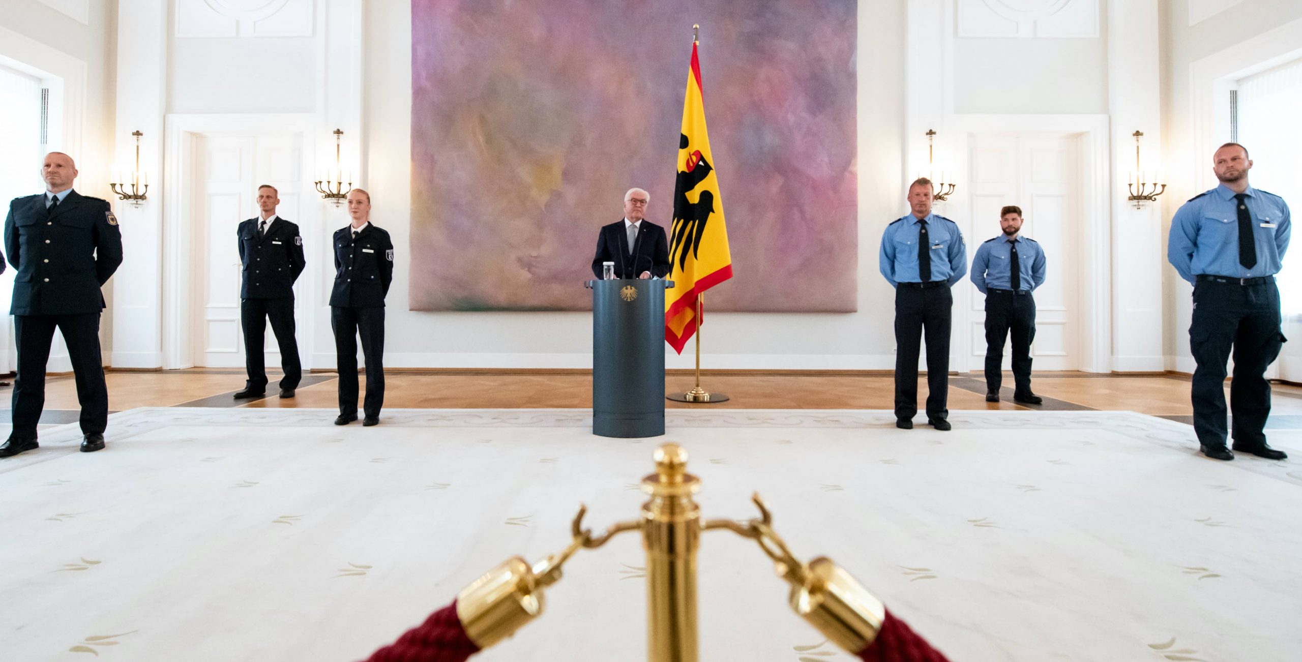 Bundespräsident Frank-Walter Steinmeier steht zwischen fünf Polizisten sowie einer Polizistin, die stellvertretend für den Einsatz der Polizei bei der Corona-Demo in Berlin geehrt wurden.