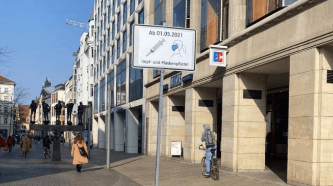 Das Foto zeigt ein Schild, das auf eine angebliche Masken- und Impfpflicht in der Leipziger Innenstadt ab 1. Mai hinweist.