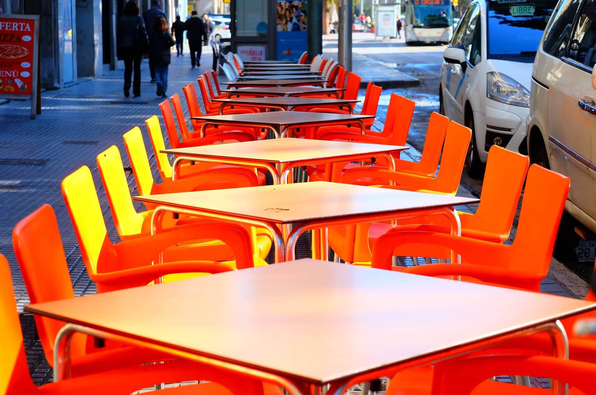 Leere Tische eines Restaurants stehen auf einer Straße