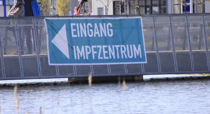 Wegweiser zu einem Impfzentrum, wo Impfstoffe verteilt werden