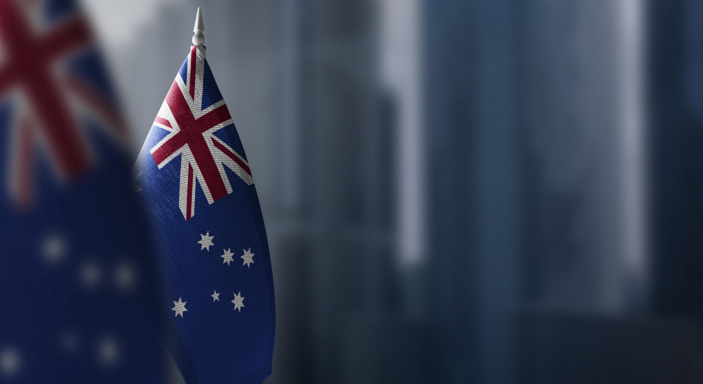 Small flags of Australia on a blurry background of the city