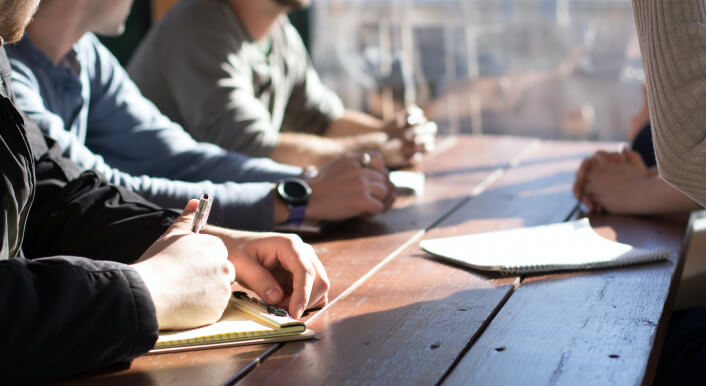 Blick in eine Redaktionskonferenz: Journalisten sitzen an einem Tisch. Im Text geht es um die innere Pressefreiheit in Lokalredaktionen. Foto: Dylan Gillis / unsplash.com