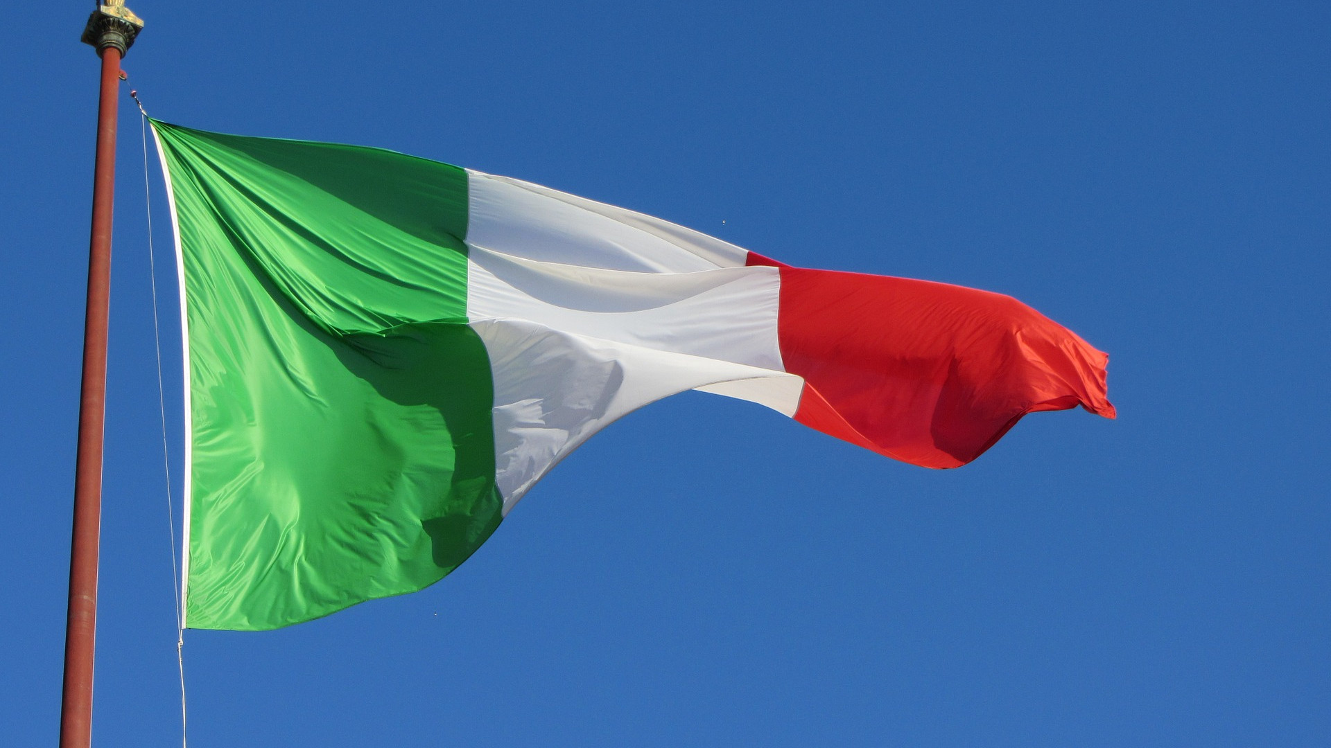 Bild einer wehenden italienischen Flagge vor blauem Himmel