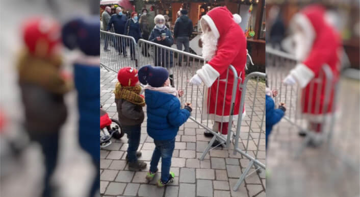 Foto vom Weihnachtsmarkt mit Zaun und Kindern