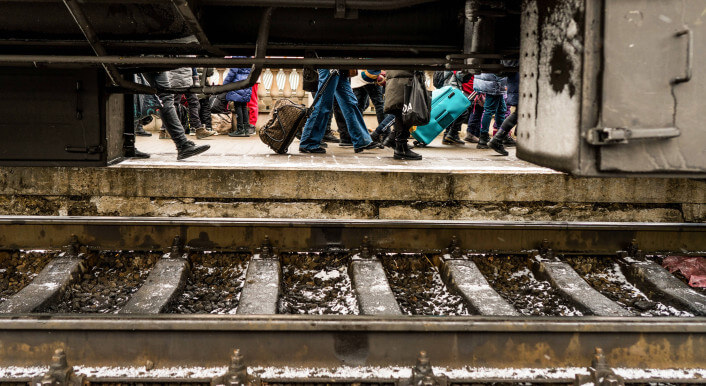 Menschen laufen an einem Zug vorbei in der Ukraine