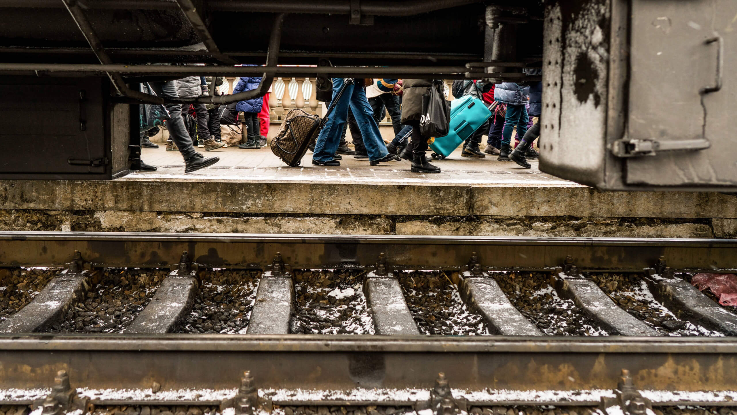 Menschen laufen an einem Zug vorbei in der Ukraine