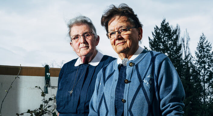 In ihrer blauen Diakonie Tracht blicken die Diakonissen Erika Lüllau (links) und Christa Friedel direkt in die Kamera