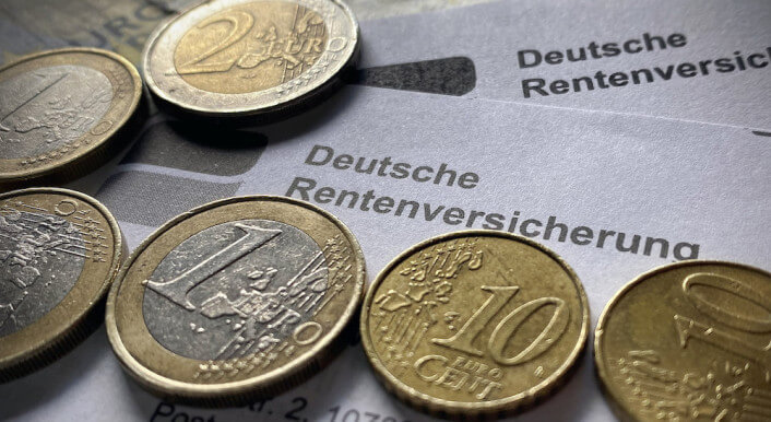 Ein Brief der Deutschen Rentenversicherung mit einigen Euromünzen und Scheinen