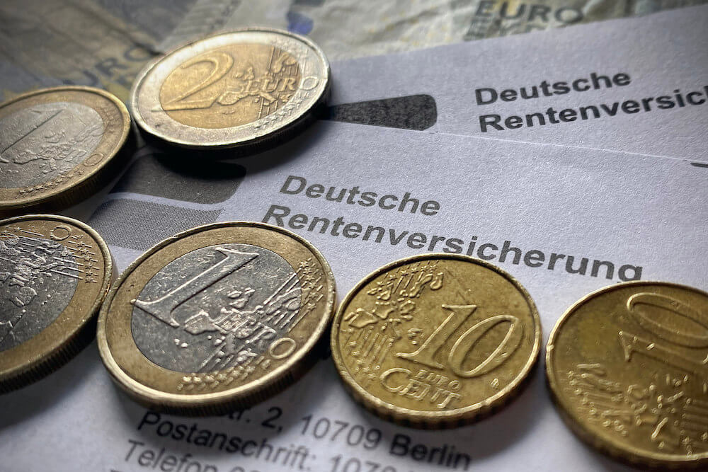 Ein Brief der Deutschen Rentenversicherung mit einigen Euromünzen und Scheinen