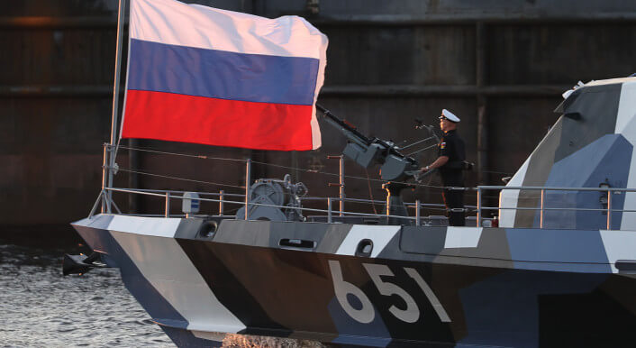 Russische Fahne und ein Seemann auf einem russischen Kriegsschiff.