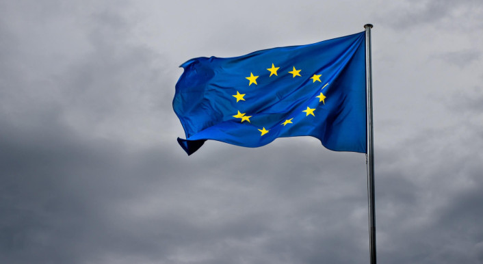 Eine wehende EU-Flagge vor einem bewölkten Himmel