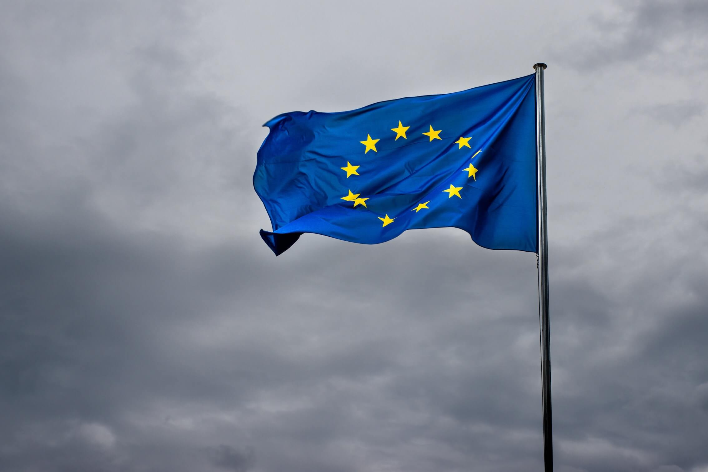 Eine wehende EU-Flagge vor einem bewölkten Himmel