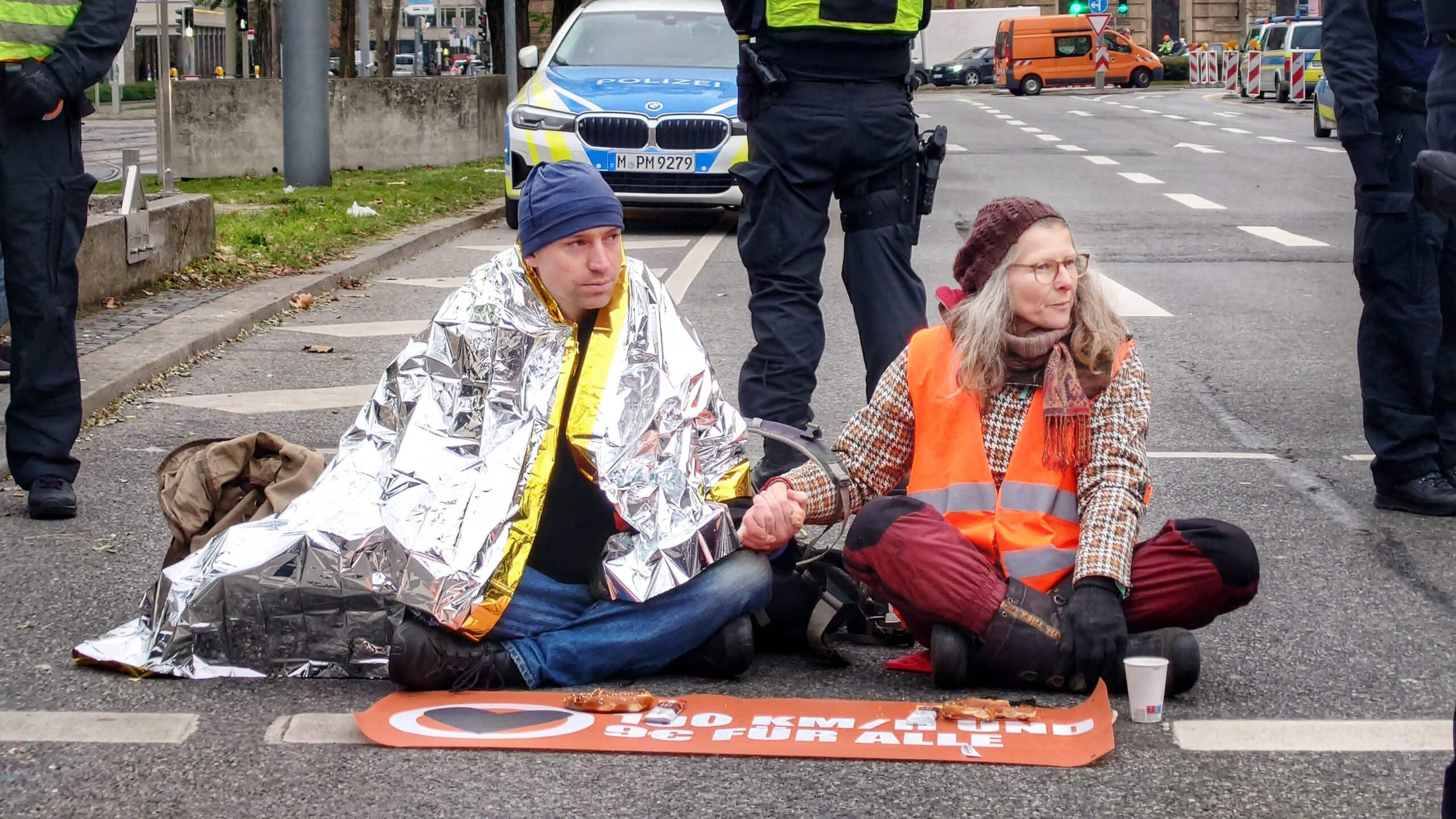 Klimaaktivisten blockieren eine Straße.