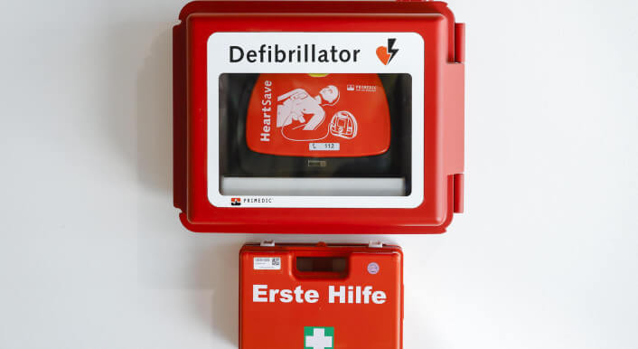 Foto eines Defibrillators und eines Erste-Hilfe-Kastens