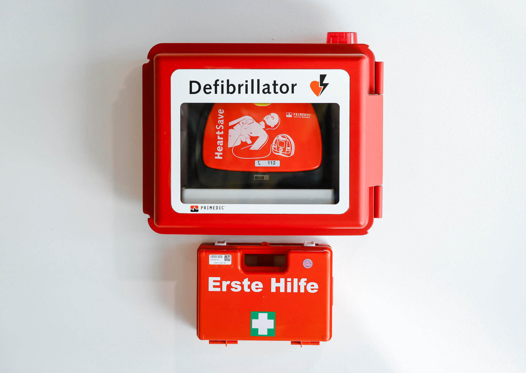 Foto eines Defibrillators und eines Erste-Hilfe-Kastens