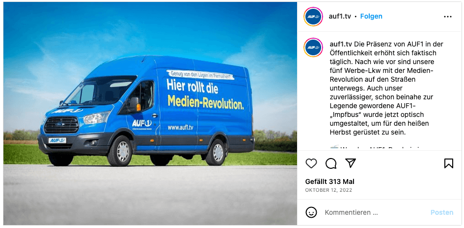 Ein blauer Bus, auf dem steht: "Hier rollt die Medien-Revolution".