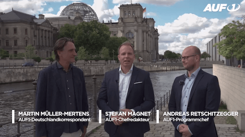 Drei Männer – Martin Müller-Mertens, Stefan Magnet und Andreas Retschitzegger – stehen an der Spree in Berlin.