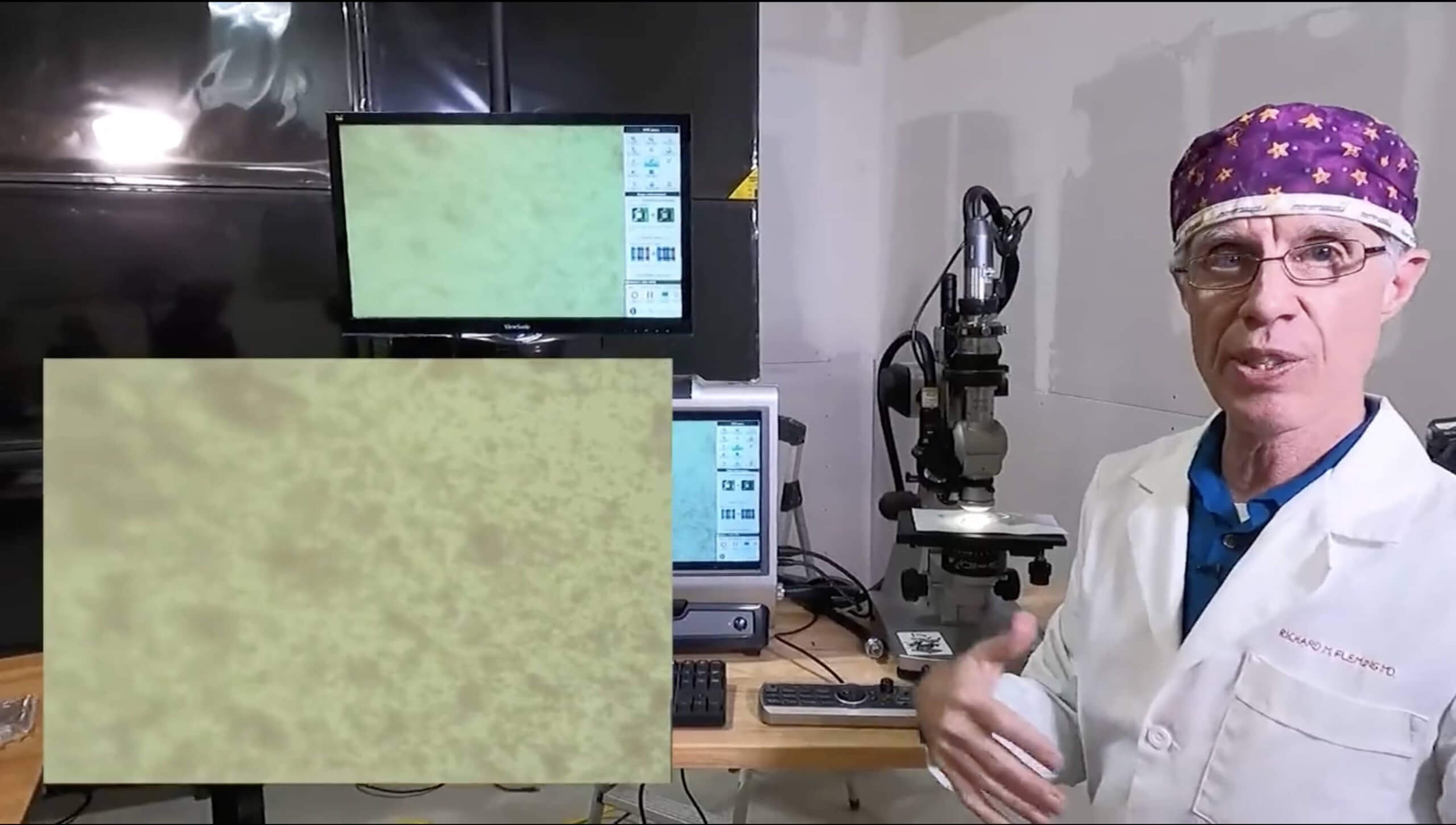 Richard M Fleming steht vor einem Mikroskop und zeigt Aufnahmen einer Blutprobe, der angeblich der Corona-Impfstoff beigemischt wurde