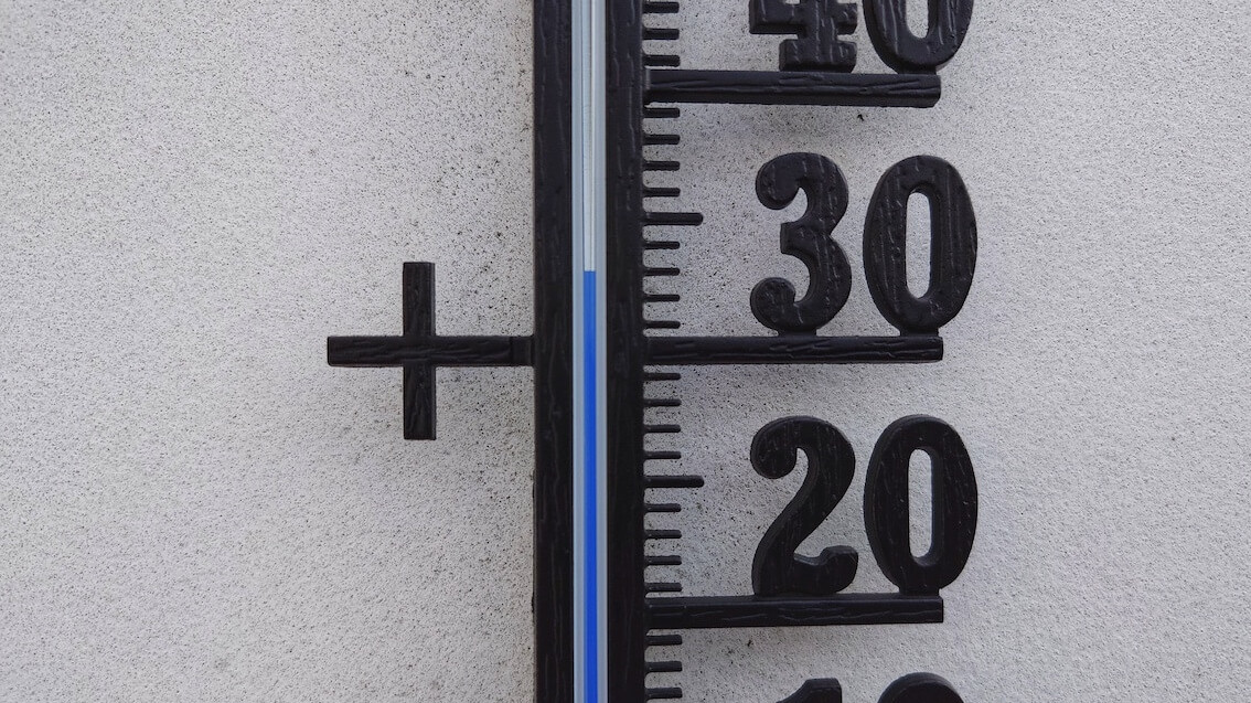 Ein Thermometer an einer weißen Hauswand
