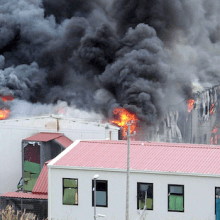 Ein Foto zeigt ein brennendes Gebäude.