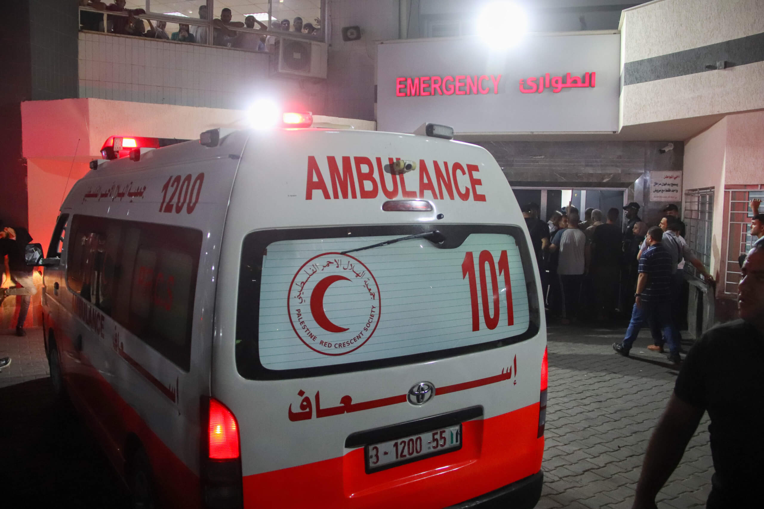 Ein Krankenwagen mit arabischer Schrift, dem Symbol des roten Halbmonds und der englischen Aufschrift Ambulance vor der Notaufnahme des Al-Shifa Krankenhauses in Gaza bei Dunkelheit.
