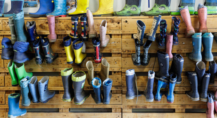 Bunte Gummistiefel hängen in einer Garderobe einer Kita