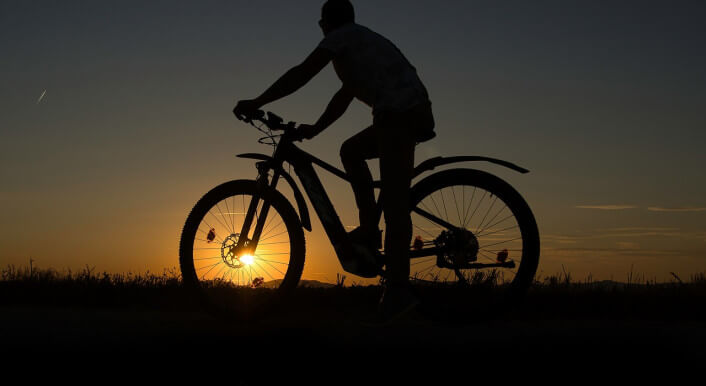 Mensch auf einem Fahrrad in der Dämmerung