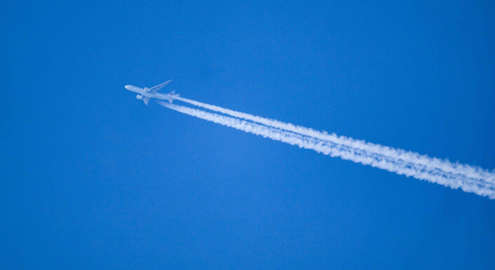 Ein Flugzeug, das Kondensstreifen bildet.