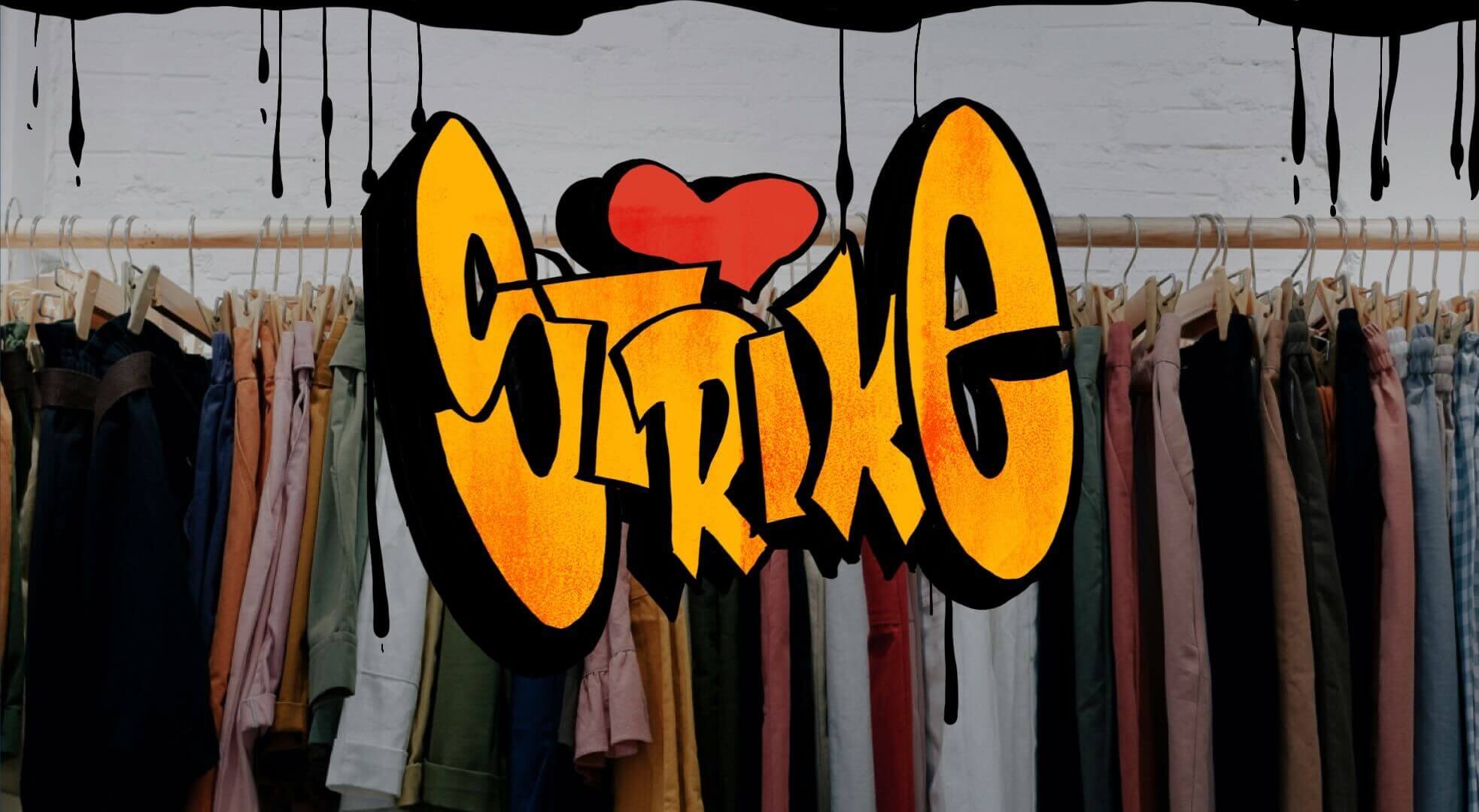 Graffiti des Firmennamens Strike mit Stange voller Vintage Kleidung im Hintergrund