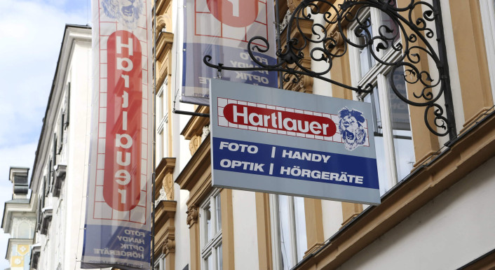 Schild an der Hauswand eines Hartlauer-Geschäfts