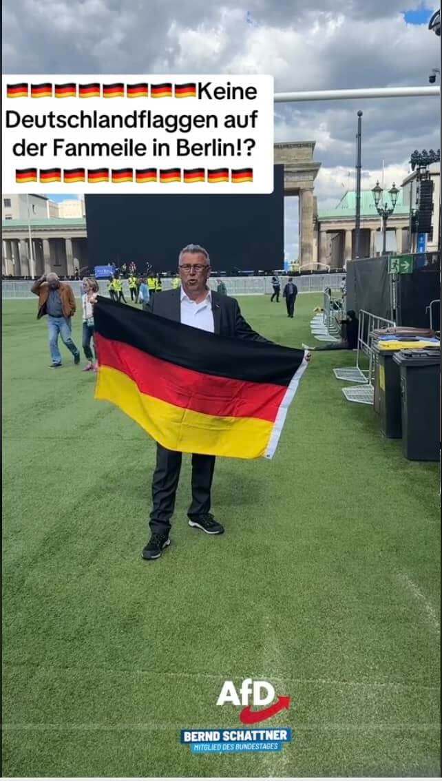 Mann auf der noch leeren Fanmeile mit Deutschland-Flagge