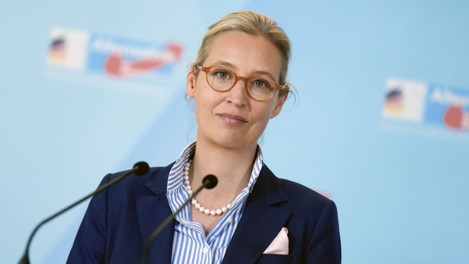 Alice Weidel sitzt an einem Mikrofon