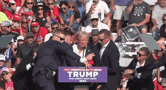 Ein Foto zeigt den Moment kurz nach den Schüssen auf Trump, zu sehen sind zwei offenbar intakte Teleprompter.