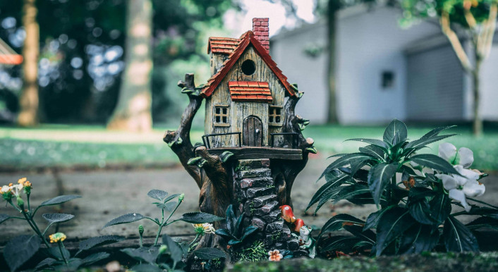 Vogelhaus, das aussieht wie ein echtes Haus, steht im Garten