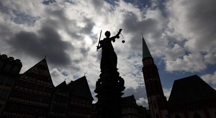 Statue von Justitia vor wolkenverhangenem Himmel