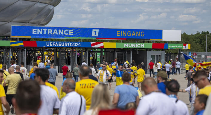 Eingangsbereich der Allianz Arena in München. Fans in gelben Trikots strömen zum Stadion, die Tickets für die EM 2024 bekommen haben.