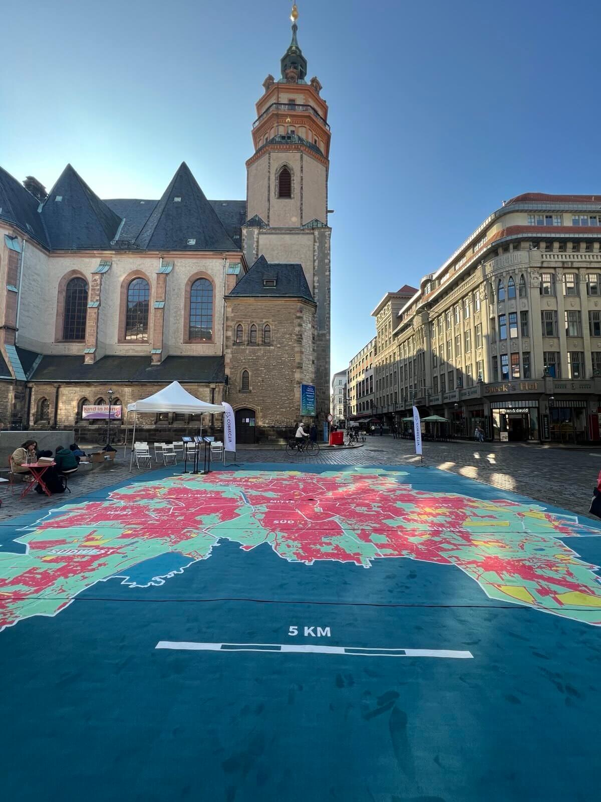 Kirche davor ein großer Teppich, der Leipzig darstellt.