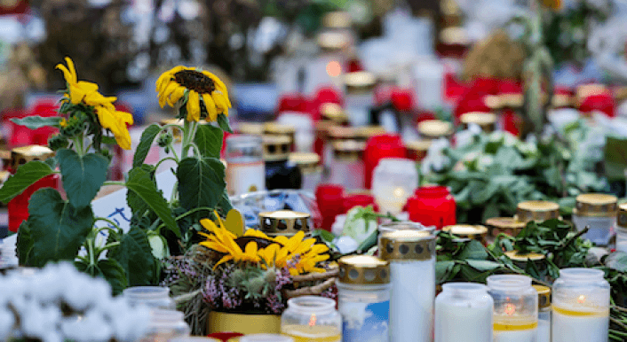 Kerzen und Blumen stehen auf dem Boden.