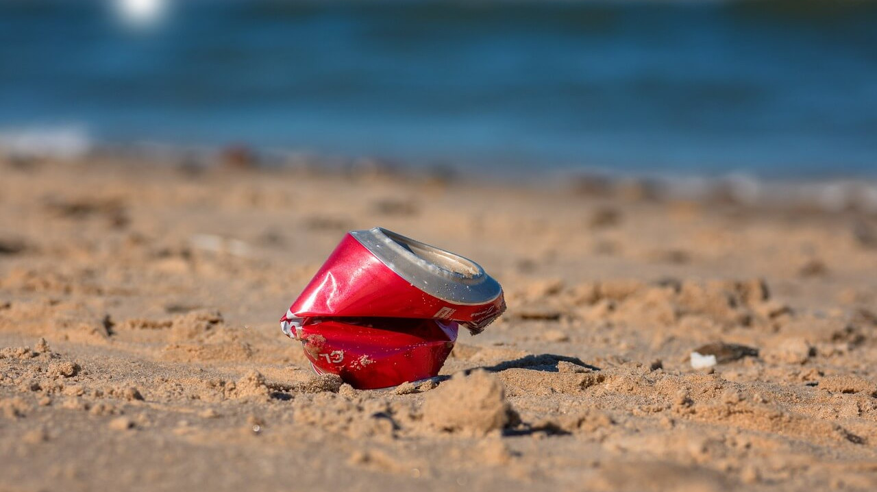 zerdrückte Dose am Strand