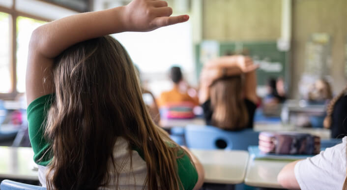Kinder sitzen im Klassenraum, ein Kind meldet sich. Eine Million Schülerinnen und Schüler sollen durch das Förderprogramm bis 2034 besser schreiben, lesen und rechnen können.