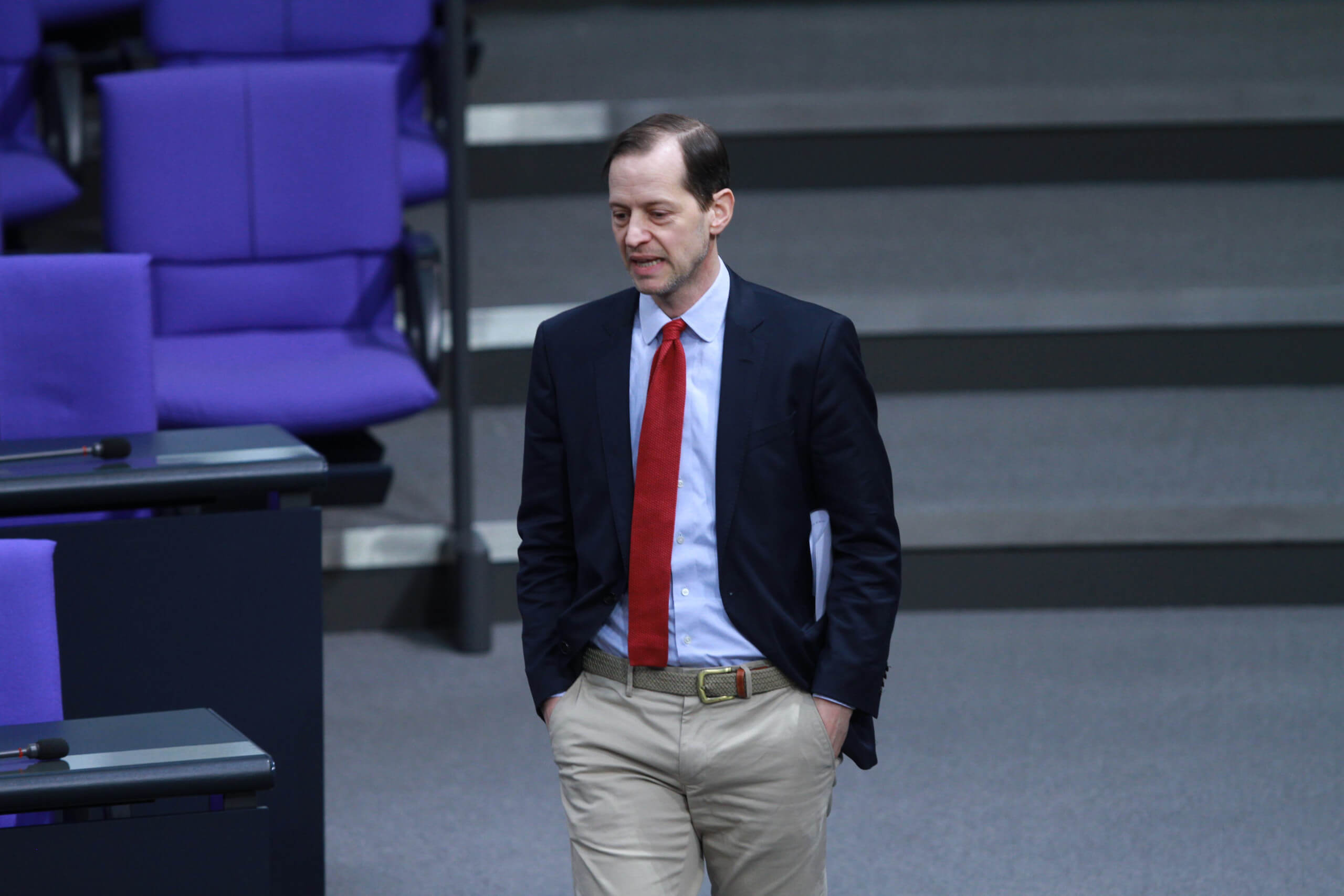 Der AfD-Abgeordnete Roger Beckamp steht mit gesenktem Kopf und im Anzug im Bundestag. Foto: picture alliance