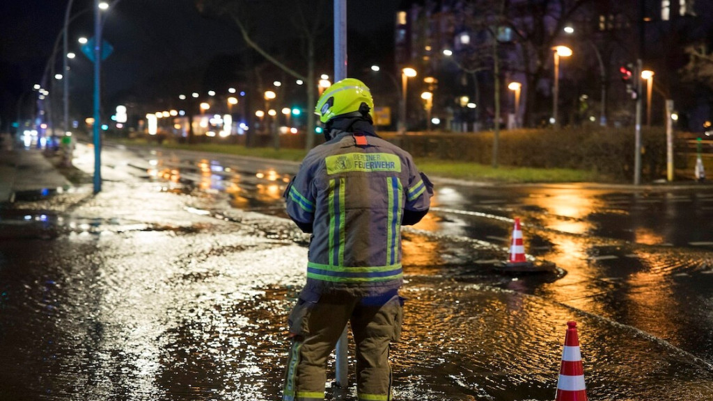 Feuerwehrmann steht auf einer überschwemmten Straße im Wedding in Berlin in der Silvesternacht