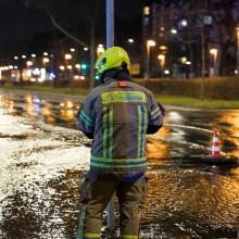 Feuerwehrmann steht auf einer überschwemmten Straße im Wedding in Berlin in der Silvesternacht