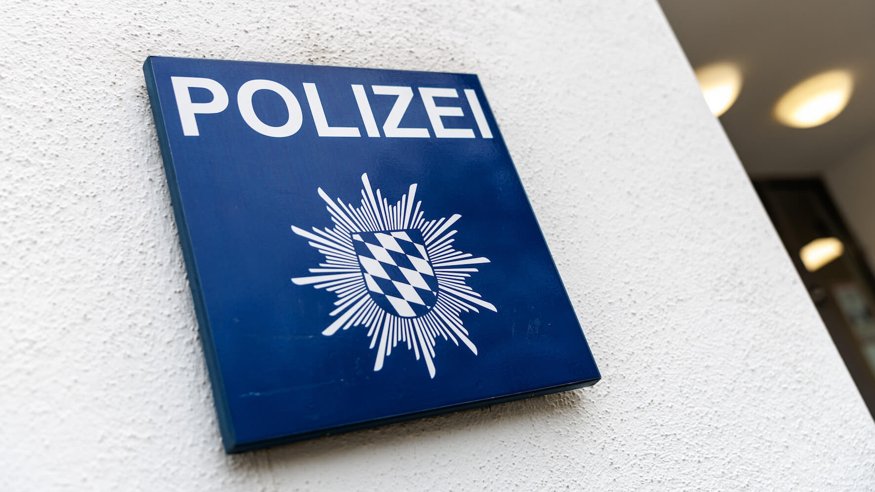 Ein Schild mit der Aufschrift Polizei ist am 27.01.2025 an der Fassade einer Polizeidienststelle in München (Bayern) zu sehen.