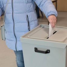 Frau wirft ihre Stimme in eine Wahlurne bei der Bundestagswahl