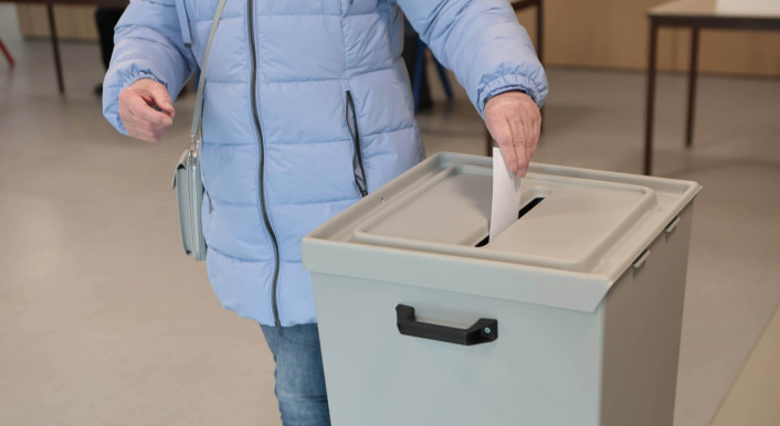 Frau wirft ihre Stimme in eine Wahlurne bei der Bundestagswahl