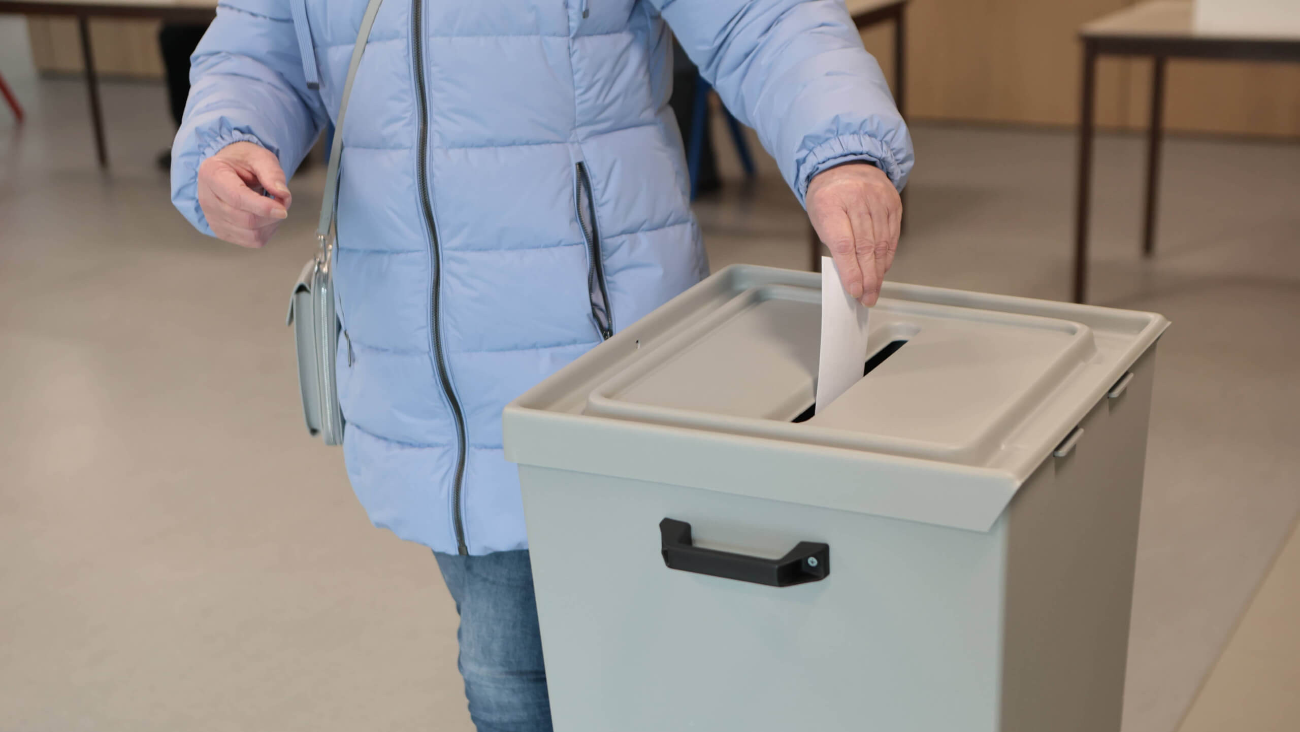 Frau wirft ihre Stimme in eine Wahlurne bei der Bundestagswahl